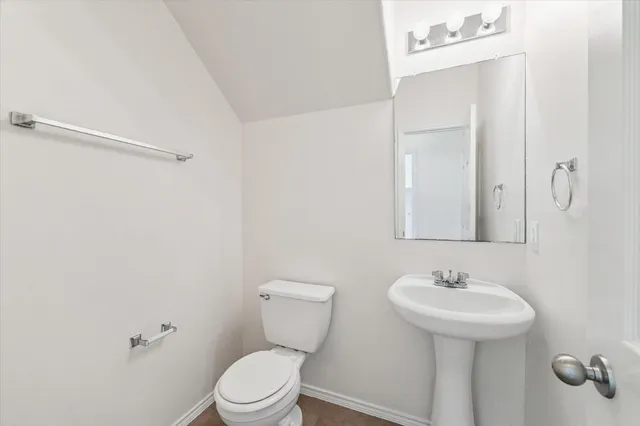a bathroom with a sink toilet and mirror