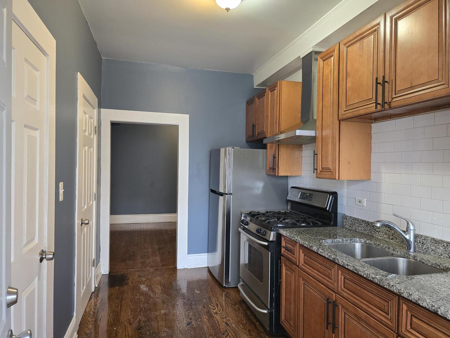 7317 South Union Avenue Chicago, IL 60621 - Photo 5 of 26 a kitchen with granite countertop stainless steel appliances a sink stove refrigerator and cabinets