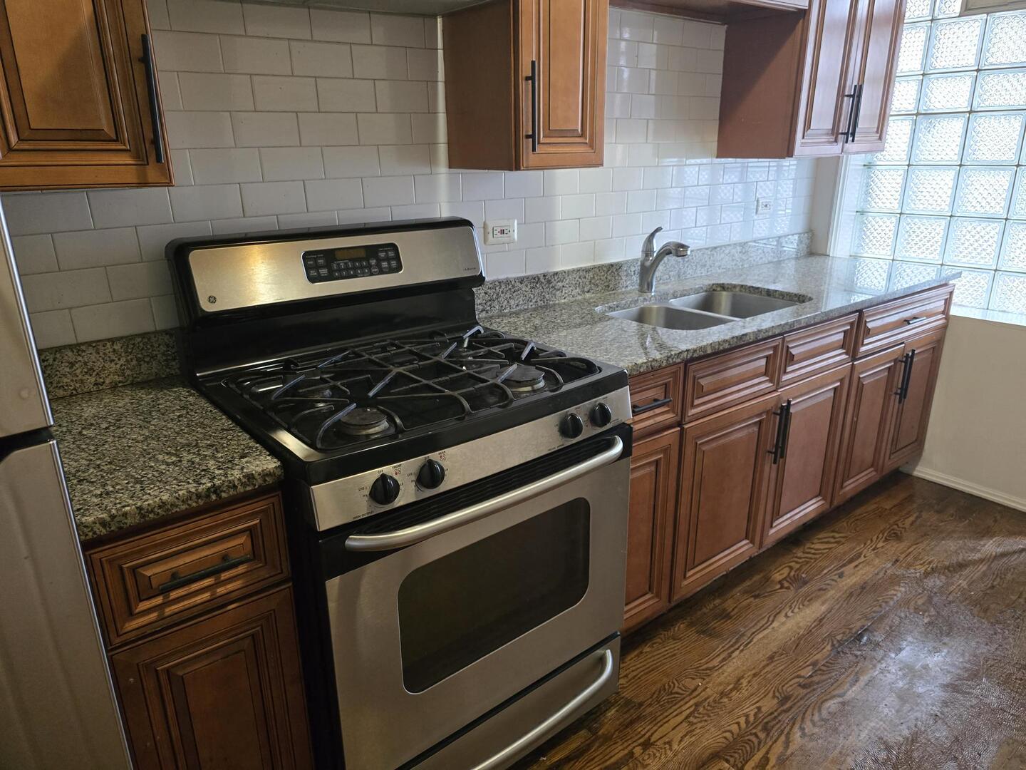 7317 South Union Avenue Chicago, IL 60621 - Photo 6 of 26 a kitchen with granite countertop a stove sink and cabinets
