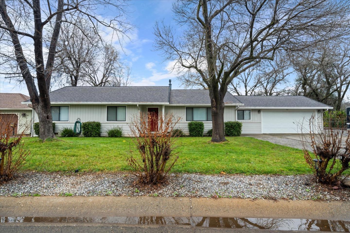 7235 Amigo Way Redding, CA 96002 - Photo 1 of 1 a front view of a house with a garden and trees