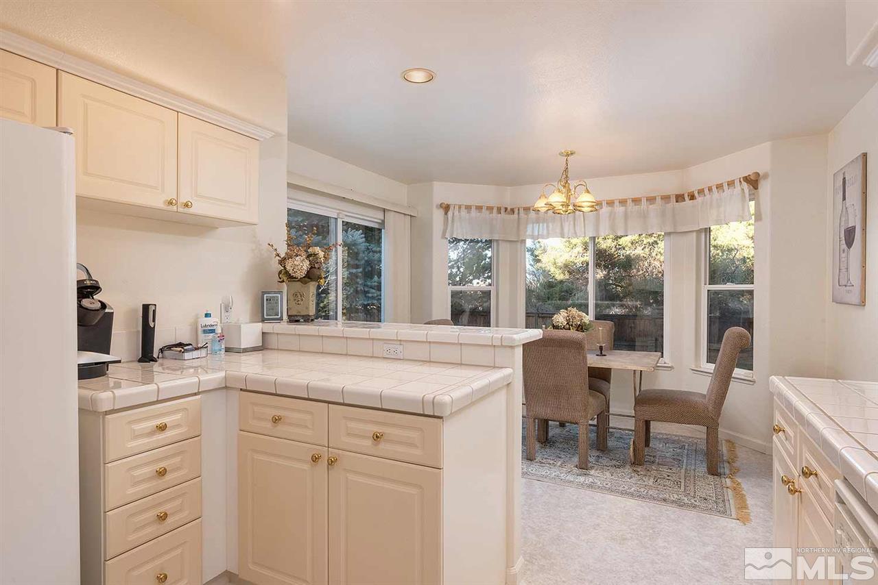 4811 East Creek Ridge Trail Reno, NV 89519 - Photo 12 of 25 a kitchen with granite countertop white cabinets and white appliances