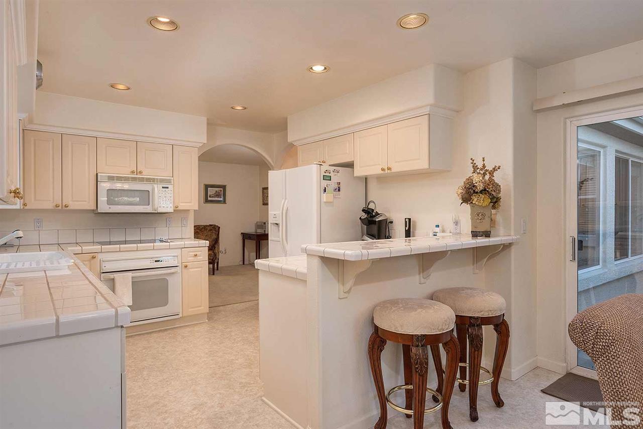 4811 East Creek Ridge Trail Reno, NV 89519 - Photo 13 of 25 a kitchen with white cabinets and stainless steel appliances
