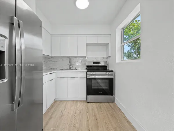 a kitchen with a stove a sink and a refrigerator