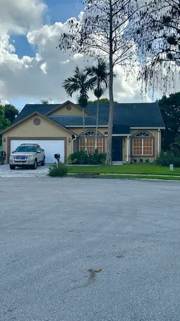 a front view of a house with a garden and trees