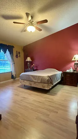 a spacious bedroom with a bed and a view of livingroom