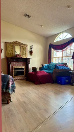 a living room with furniture a fireplace and a large window