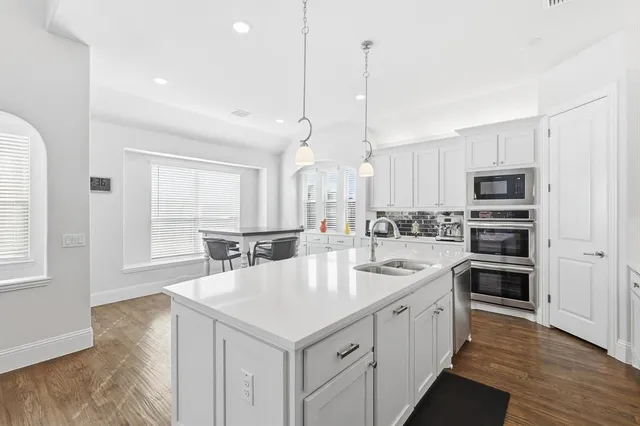 a large kitchen with kitchen island a sink appliances and cabinets