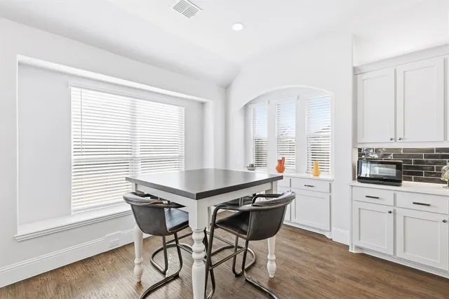 a kitchen with a table chairs and a window