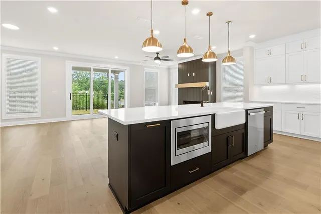 a kitchen with a stove a sink a window and wooden floor