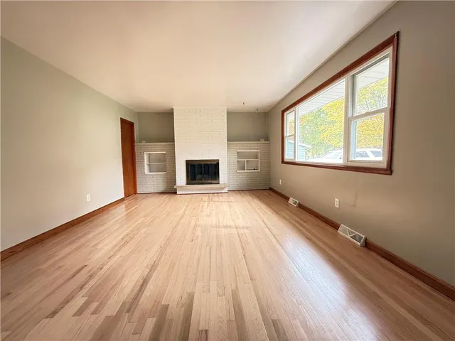 a large kitchen with stainless steel appliances granite countertop a stove a sink dishwasher and a refrigerator with wooden floor