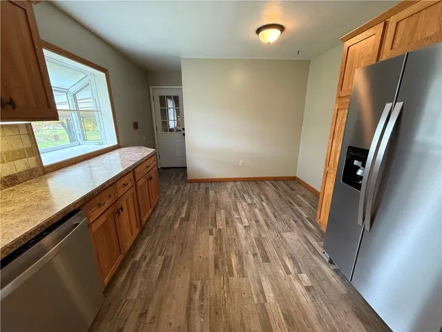 a kitchen with stainless steel appliances granite countertop a refrigerator a stove and a sink with cabinets