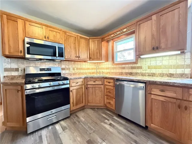 a kitchen with stainless steel appliances granite countertop a stove a sink and a microwave