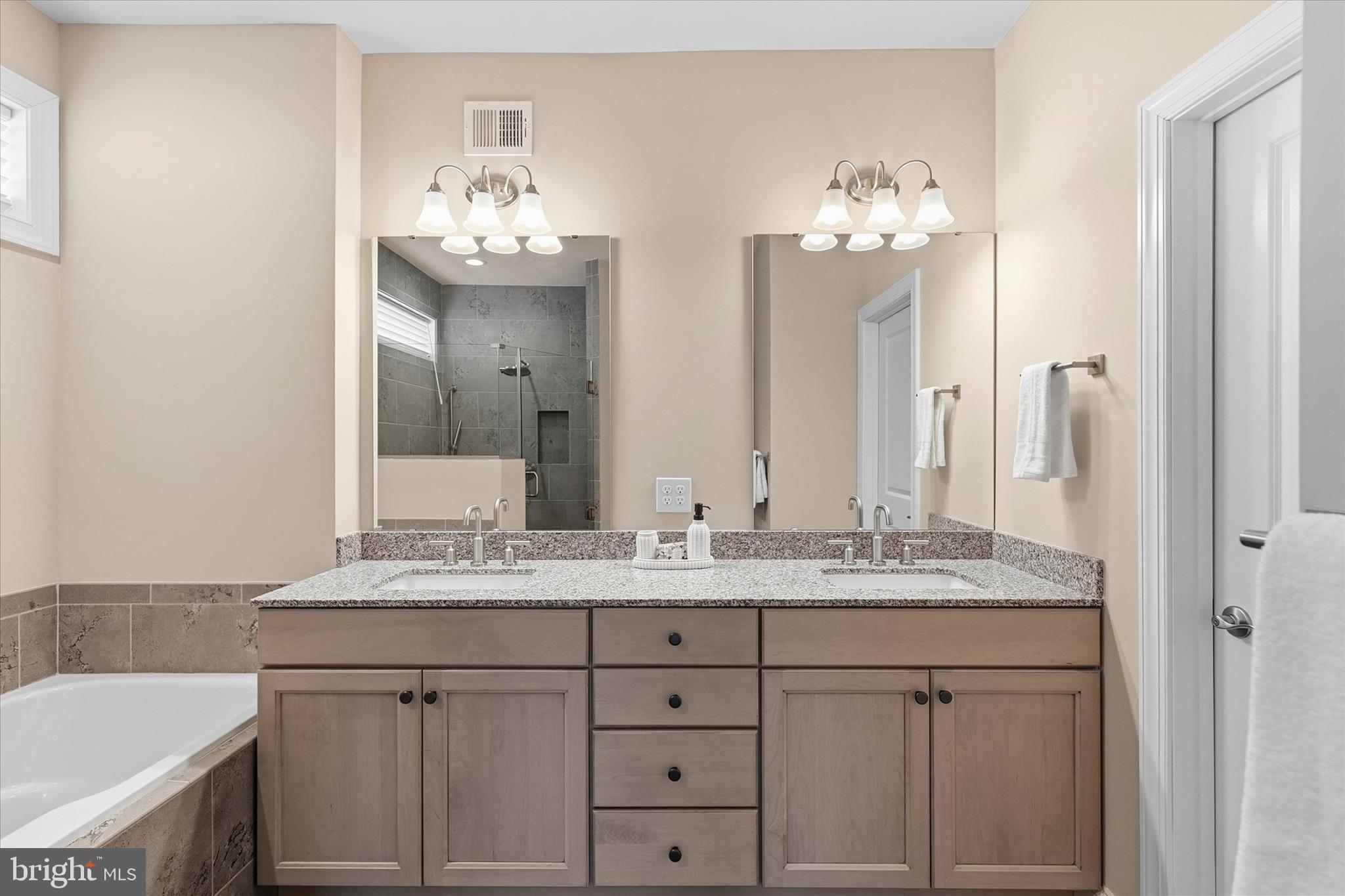 30475 Madeira Lane Ocean View, DE 19970 - Photo 16 of 31 a bathroom with a sink double vanity granite tub and a mirror