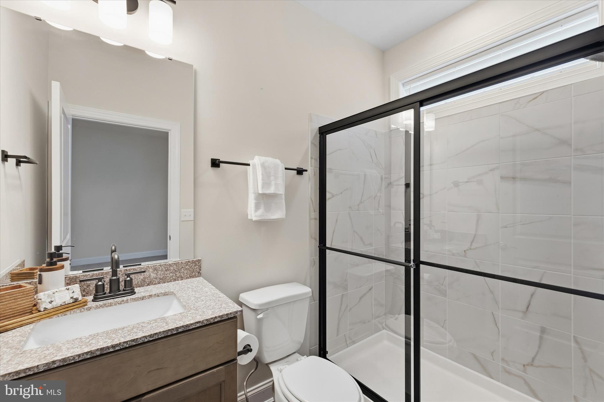 30475 Madeira Lane Ocean View, DE 19970 - Photo 21 of 31 a bathroom with a granite countertop sink mirror vanity and toilet