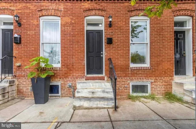a view of a brick house with potted plants