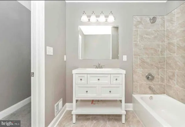 a bathroom with a sink mirror and a bathtub