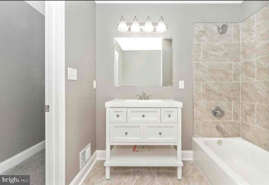 1112 Rutland Avenue Baltimore, MD 21213 - Photo 12 of 22 a bathroom with a sink mirror and a bathtub