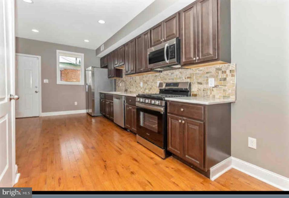1112 Rutland Avenue Baltimore, MD 21213 - Photo 4 of 22 a kitchen with stainless steel appliances granite countertop a stove a sink and a microwave