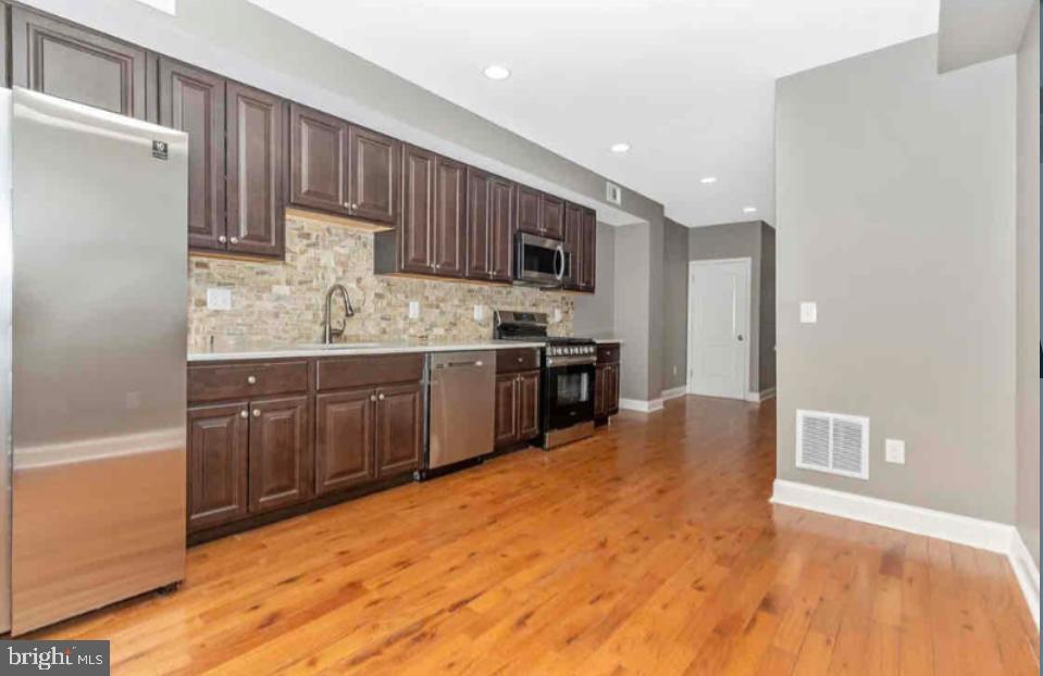 1112 Rutland Avenue Baltimore, MD 21213 - Photo 5 of 22 a kitchen with stainless steel appliances granite countertop a stove a sink and a refrigerator