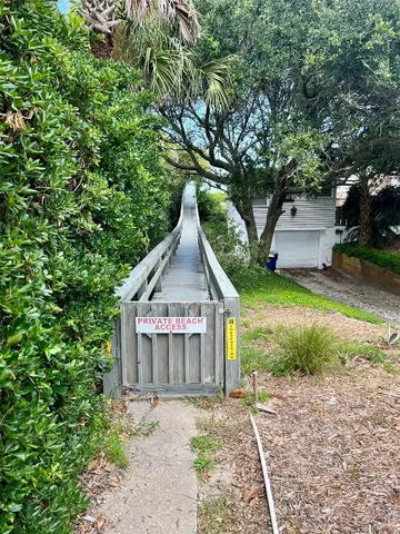 a view of a house with a yard and large trees