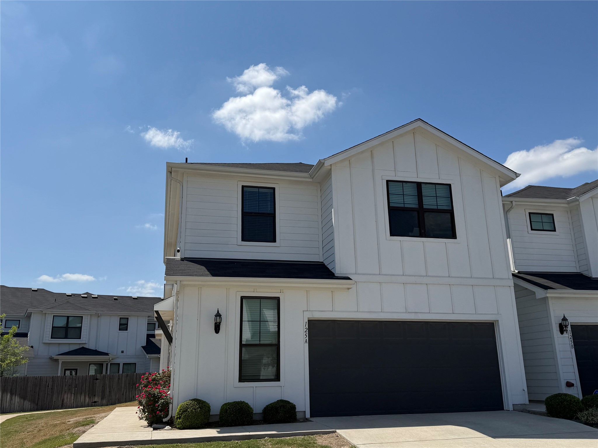 125 Threshing Road, Unit A Buda, TX 78610 - Photo 1 of 23 Modern farmhouse with board and batten siding, a garage, and concrete driveway