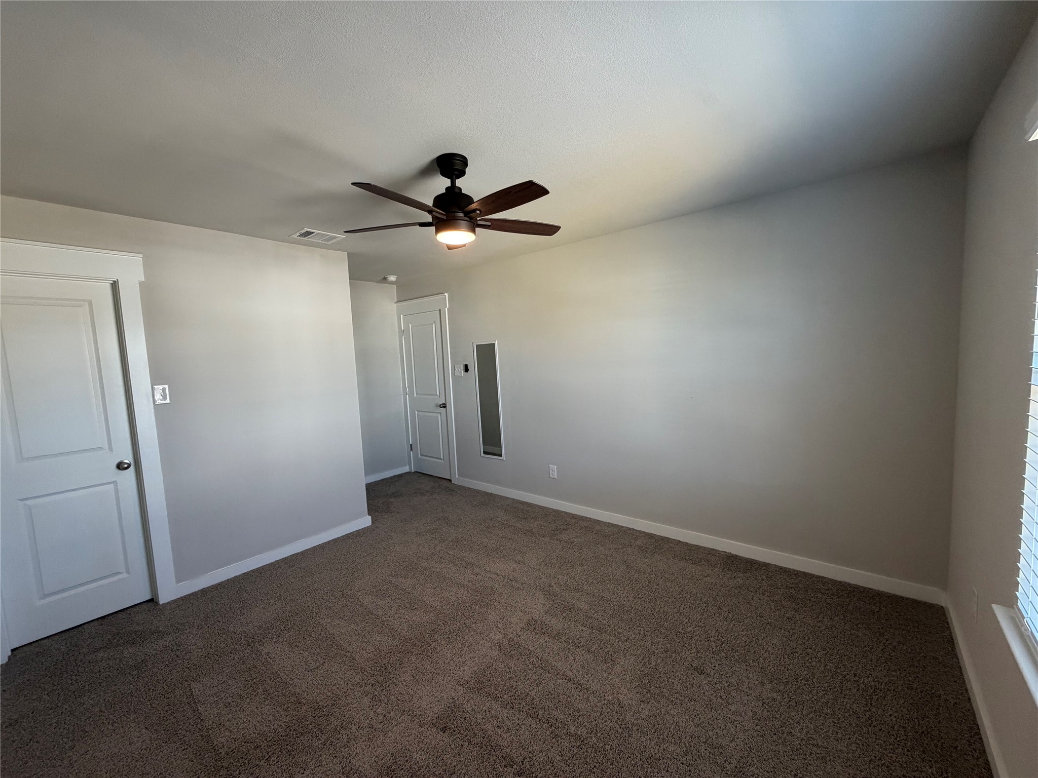 125 Threshing Road, Unit A Buda, TX 78610 - Photo 15 of 23 Spare room with dark carpet and ceiling fan