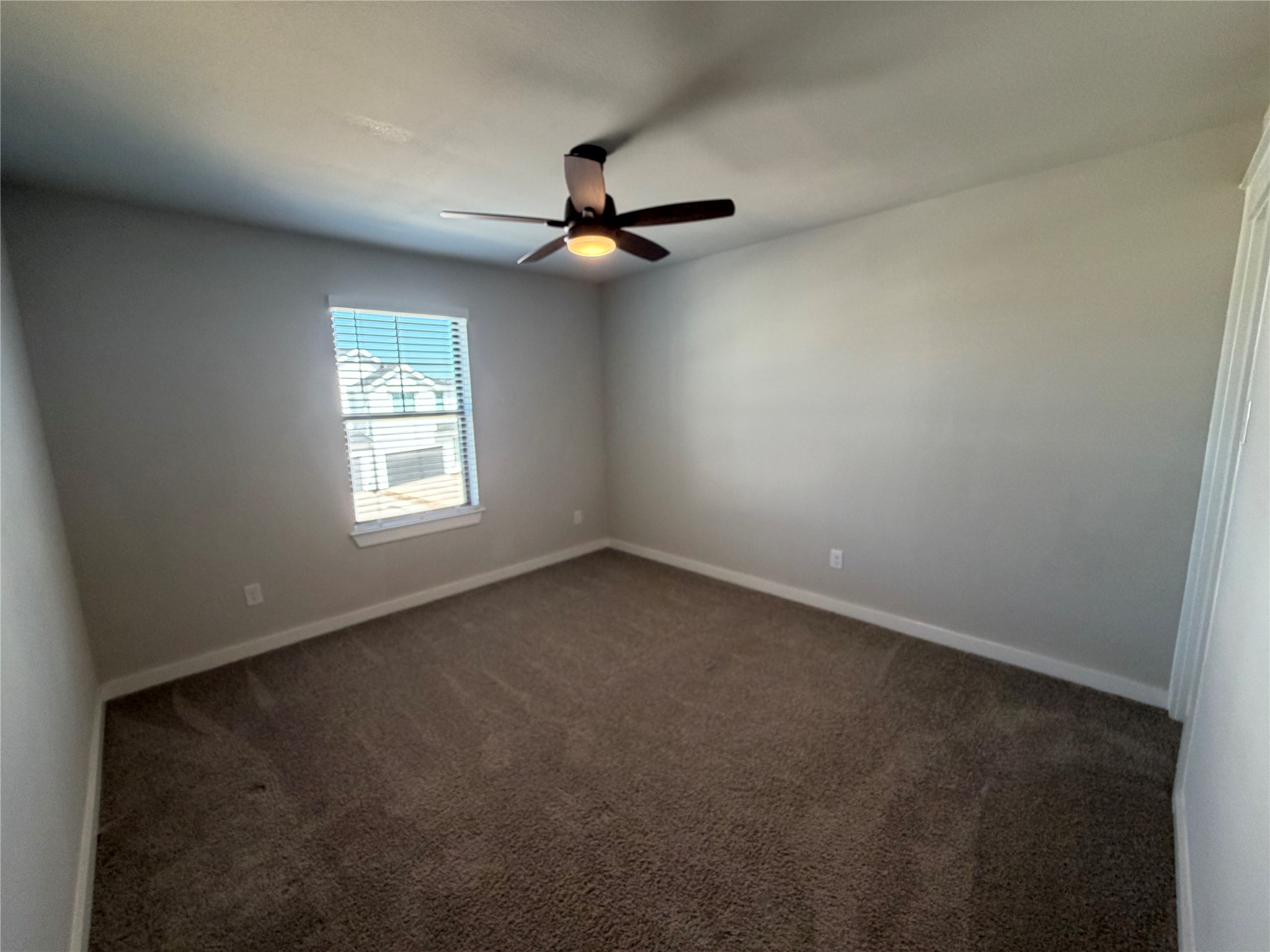 125 Threshing Road, Unit A Buda, TX 78610 - Photo 16 of 23 Spare room featuring dark colored carpet and a ceiling fan