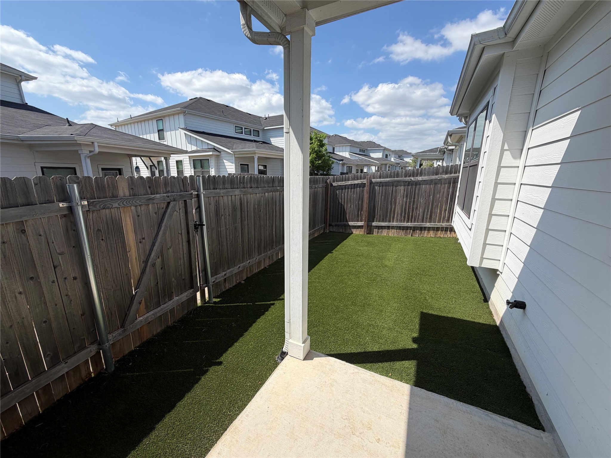 125 Threshing Road, Unit A Buda, TX 78610 - Photo 18 of 23 Fenced backyard with a patio, a residential view, and a gate