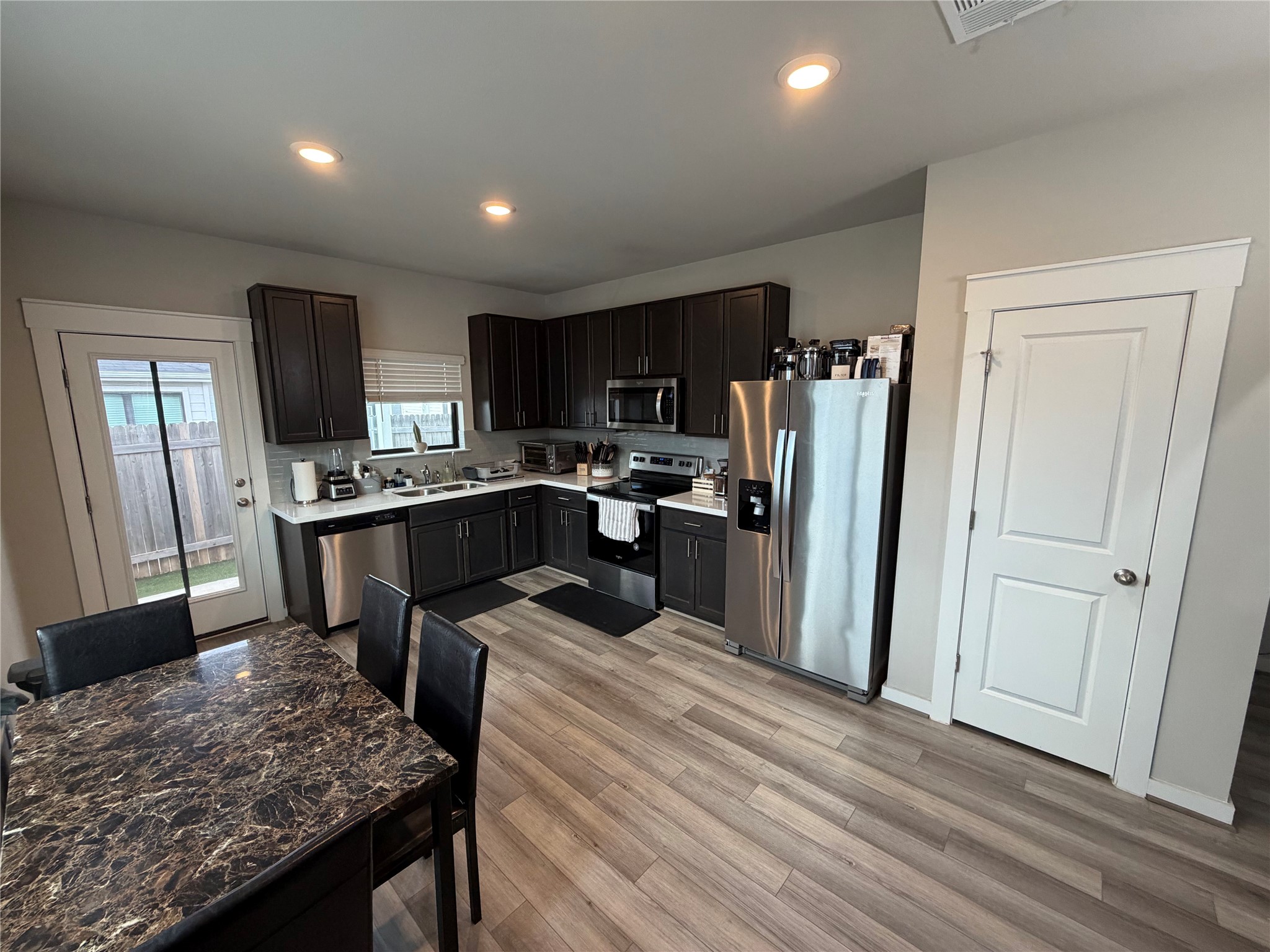 125 Threshing Road, Unit A Buda, TX 78610 - Photo 3 of 23 Kitchen featuring light countertops, stainless steel appliances, recessed lighting, and light wood finished floors