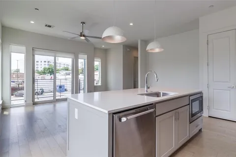 a kitchen with a sink chandelier and wooden floor