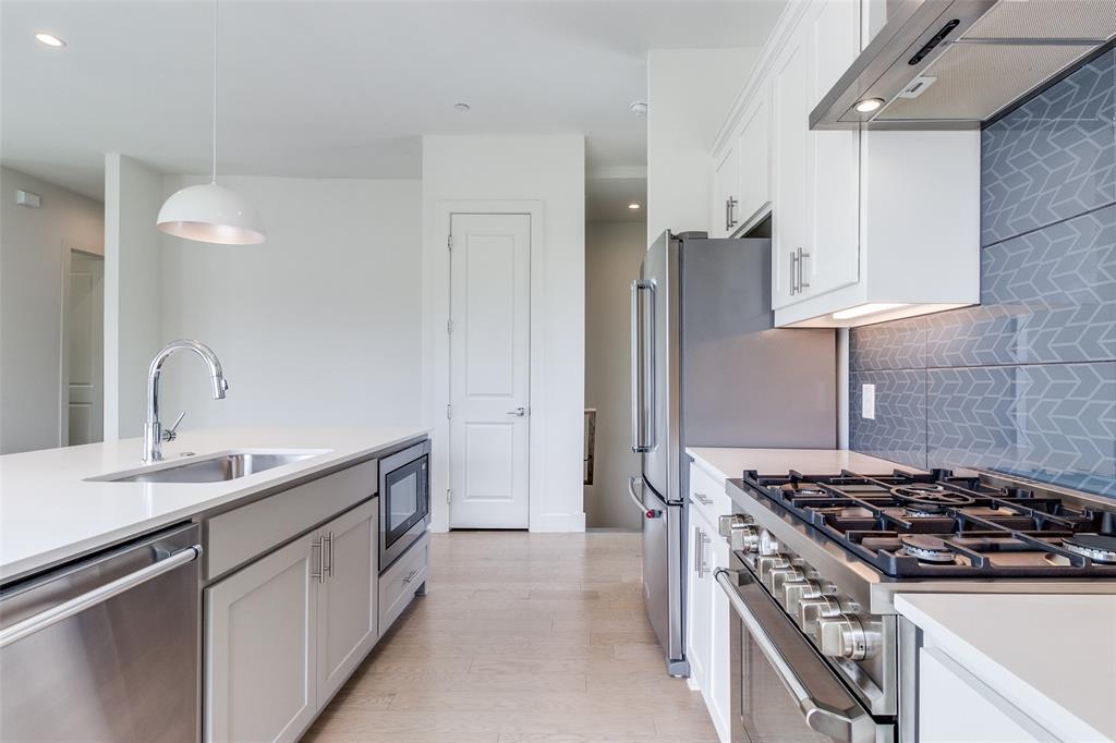 5515 Bryan Parkway, Unit 101 Dallas, TX 75206 - Photo 13 of 19 a kitchen with stainless steel appliances a sink a stove and a refrigerator