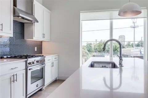 a kitchen with a stove a sink and a window