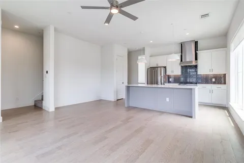 a large kitchen with cabinets and wooden floor