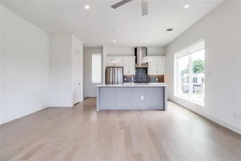 a large kitchen with a wooden floor and a large window