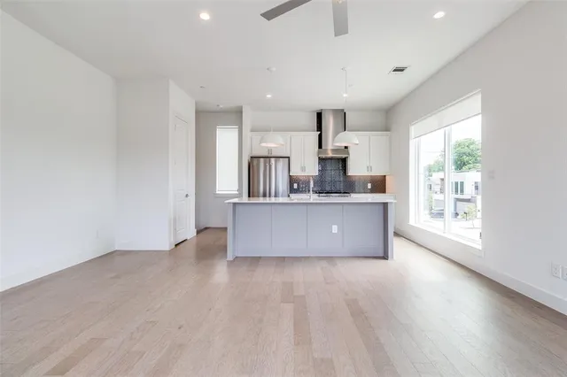 a large kitchen with a wooden floor and a large window