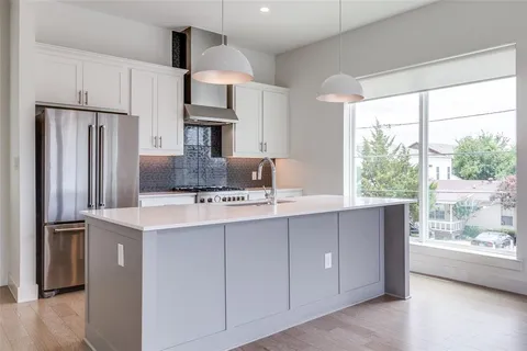 a kitchen with stainless steel appliances a sink and a refrigerator