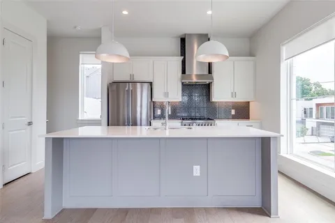 a kitchen with stainless steel appliances a sink a stove a refrigerator and cabinets