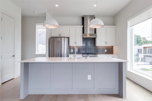 a kitchen with stainless steel appliances a sink a stove a refrigerator and cabinets
