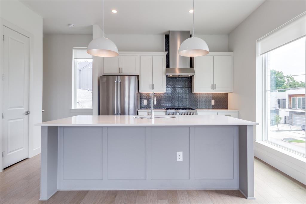 5515 Bryan Parkway, Unit 101 Dallas, TX 75206 - Photo 10 of 19 a kitchen with stainless steel appliances a sink a stove a refrigerator and cabinets
