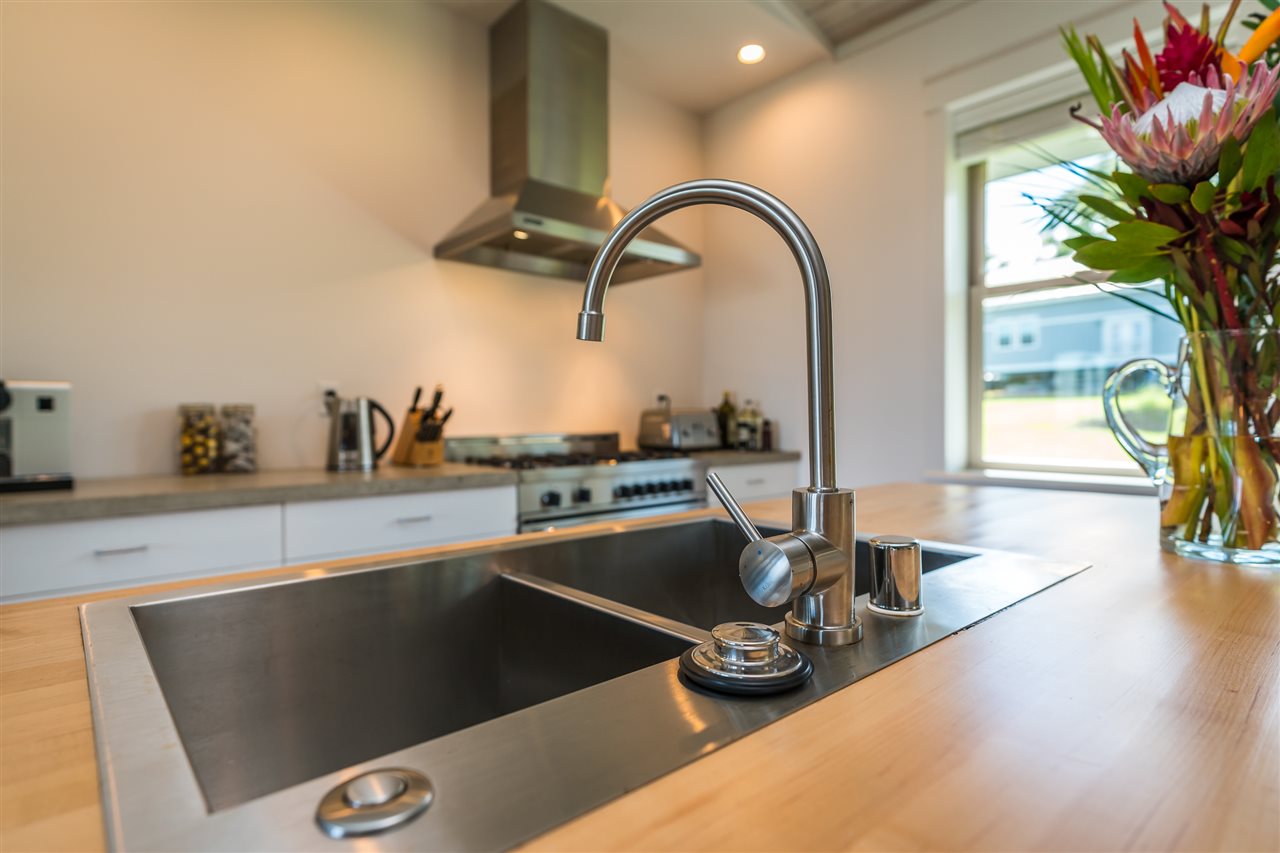 1809 Haiku Road, Unit C Haiku, HI 96708 - Photo 7 of 26 a kitchen with a sink and a stove with wooden floor