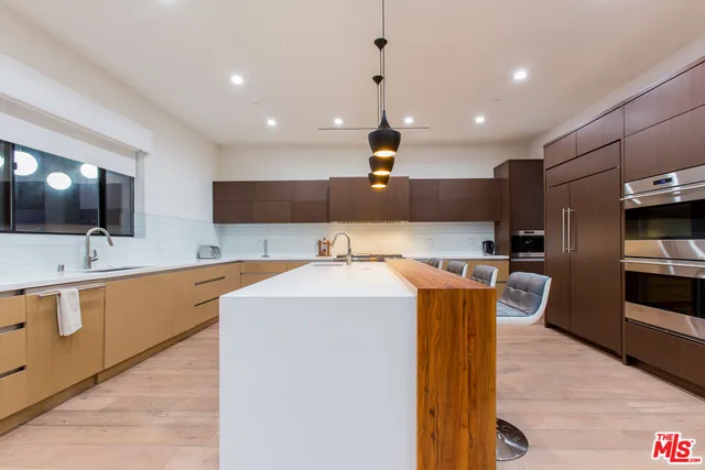 a large kitchen with stainless steel appliances kitchen island granite countertop a sink and cabinets