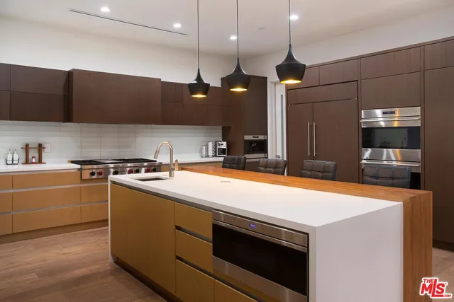 a kitchen with stainless steel appliances granite countertop a sink a stove and a refrigerator