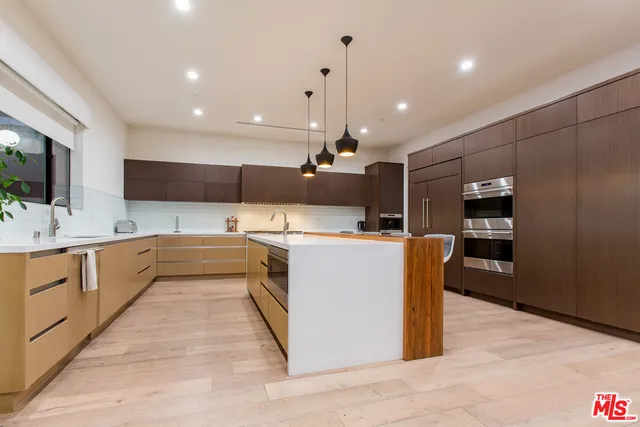 a large kitchen with kitchen island a sink stainless steel appliances and cabinets