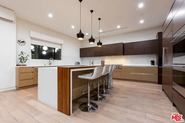 a kitchen with stainless steel appliances kitchen island granite countertop a sink a stove a refrigerator and a microwave