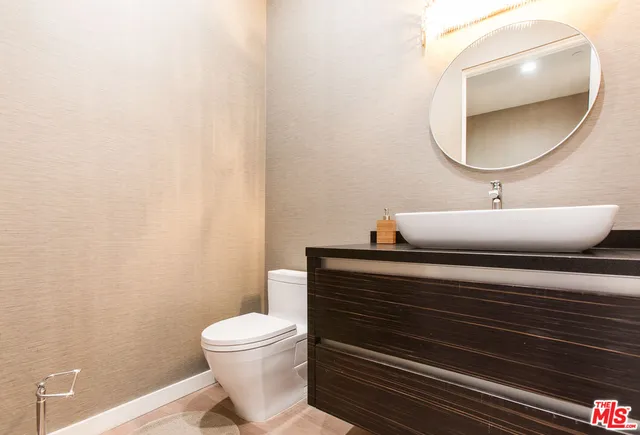 a bathroom with a toilet a sink and mirror