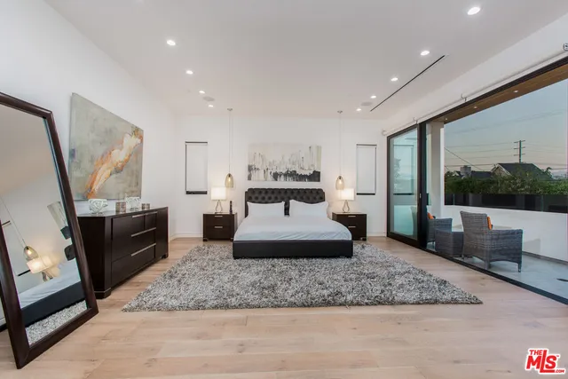 a spacious bedroom with a large bed and a dresser