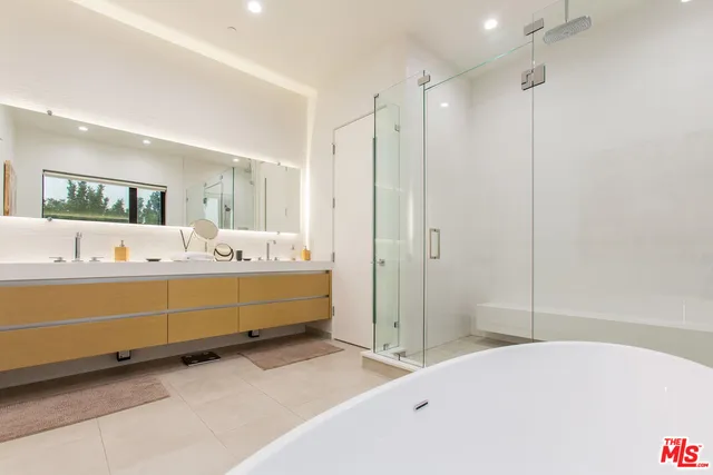 a spacious bathroom with a double vanity sink tub and mirror