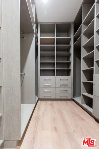 a view of walk in closet with empty racks