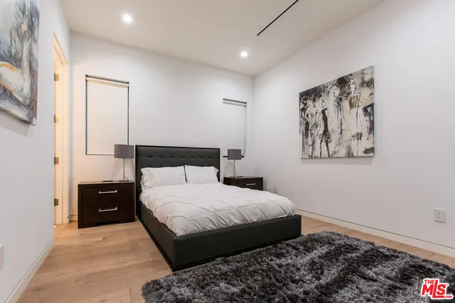 a bedroom with a bed and a painting on the wall