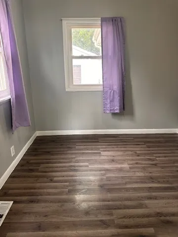 a view of a room with wooden floor and window